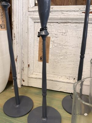 Świecznik smukły Grigio-Świecznik metalowy grafitowy 33 cm na smukłej nóżce. Grafitowy świecznik metalowy o wysokości 33 cm łączy smukłą nóżkę, okrągłą podstawę i wydłużony kielich. Ciemna powierzchnia z widoczną fakturą oraz jaśniejszymi przetarciami nadaje mu lekko surowy wygląd. To dekoracyjny akcent na stół, komodę lub konsolę, pasujący do drewna, jasnej ceramiki i szkła.