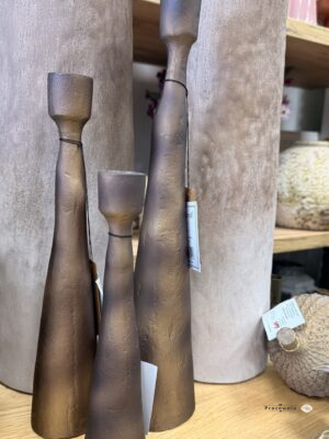 Świecznik Modern- Świecznik aluminiowy smukły w kolorze miedzi 23 cm. Świecznik aluminiowy o wysokości 23 cm łączy smukłą sylwetkę z przygaszonym odcieniem miedzi i delikatnie nierówną fakturą. To niewielki dodatek do dekoracji stołu, komody lub konsoli, który dobrze komponuje się z drewnem, jasną ceramiką i szkłem.