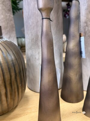 Świecznik Modern-Świecznik aluminiowy smukły w kolorze miedzi 29 cm. Smukły świecznik aluminiowy o wysokości 29 cm wyróżnia się ciepłym, miedzianym kolorem i delikatnie nieregularną fakturą. Korpus zwężający się ku górze przechodzi w niewielki kielich, tworząc prostą, rzeźbiarską formę. To dodatek na stół, konsolę lub komodę, który dobrze komponuje się z ceramiką, drewnem i przydymionym szkłem.